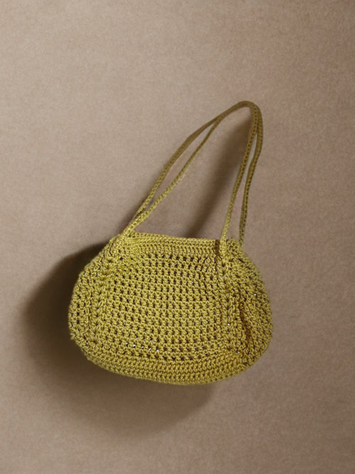 A small yellow crocheted shoulder bag with a single strap, photographed against a plain beige background.